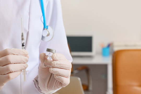 Female doctor with hormone injection and ampule in clinic, closeup