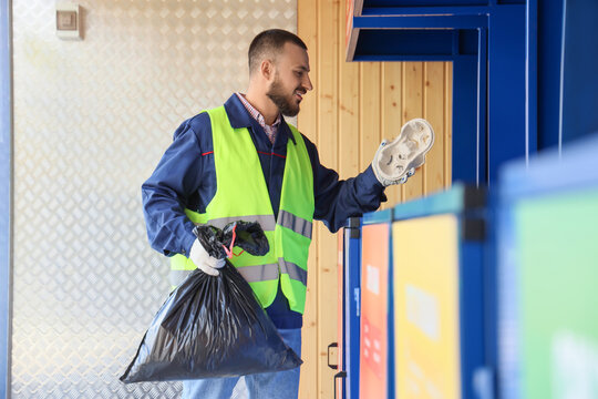 Male scavenger throwing paper garbage in trash bin area