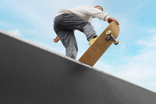 Young man with skateboard at skatepark