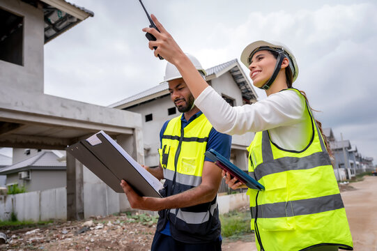 Civil construction site managers holding clipboard at residential construction site, inspection unfinished residential building during daytime, scene of house inspection and real estate development.