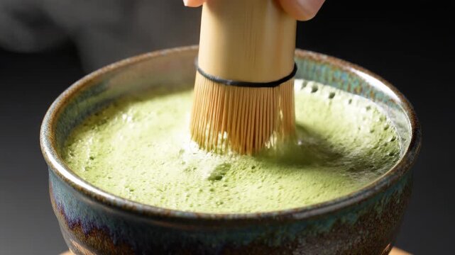 Making traditional Japanese matcha green tea ceremony, whisking powder with bamboo chasen in rustic bowl, frothy drink preparation, cultural beverage, close-up shot