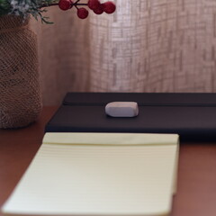 Una mesa de madera con un adorno de navidad una libreta de papel y varios objetos de escritorio  © Elika R