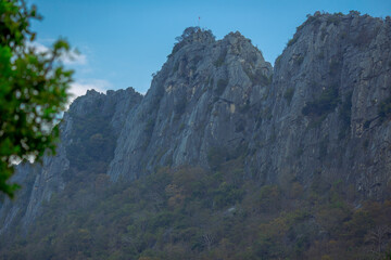 Fototapeta premium Natural background on the top of a high mountain with panoramic view of trees, sky, big mountains and cool breeze blowing while traveling in nature.