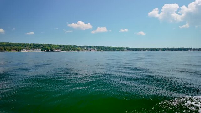 View from a boat on the calm waters of Green Bay looking back toward the village of Ephraim, Wisconsin, on a beautiful summer day in Door County.
