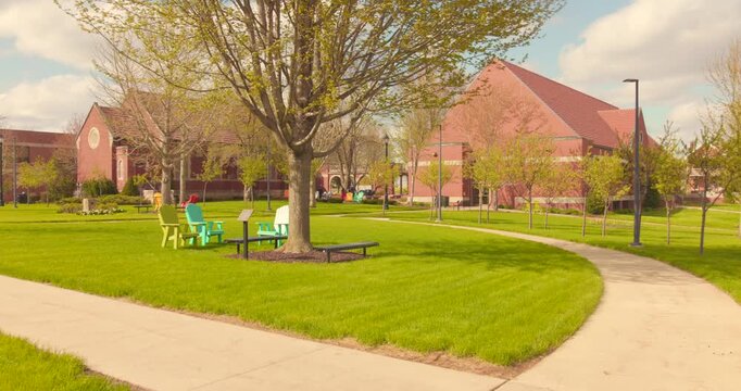 Campus green area with outdoor learning site beneath a large tree and winding footpath near University of Dubuque, Iowa, USA