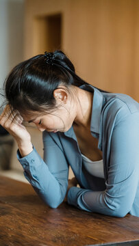 Distressed woman crying at table suffering from stress anxiety and heartbreak