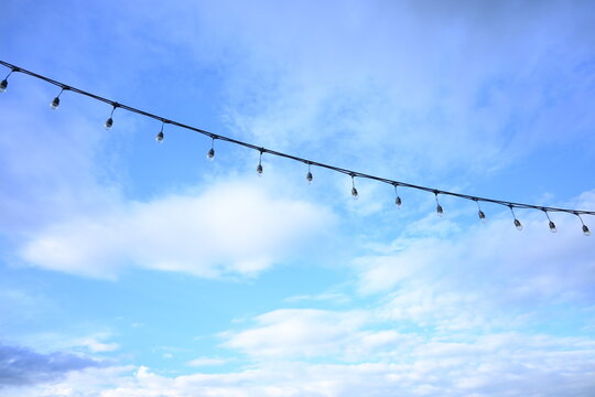 decorative string light hanging outdoors under a clear daylight sky