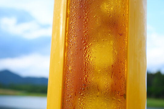 cold draft beer serve in a transparent plastic tower cup