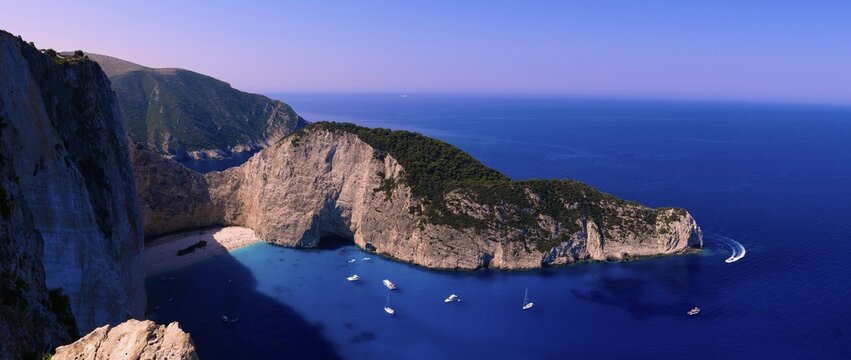 Paralia Navagio, Shipwreck Beach, panoramic photo, rocky cliff, shipwreck MV Panagiotis, excursion boats, blue and turquoise crystal clear sea, cloudless blue sky, Zakynthos, Ionian Islands, Greece