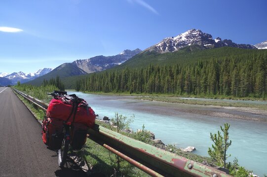 Packed bike leaning against the road, mountains and mountain river, adventure, Icefields Parkway, Jasper National Park, Alberta, Canada