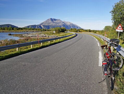 Bicycle in front of traffic sign on a narrow road warning of sheep, Mountains and Sea TJotta, Kystriksveien, FV 17, Helgeland, Norway