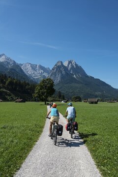 Cyclists on bike tour, cycle path with mountain bike, behind Zugspitze, Tegernauweg, near Grainau, crossing the Alps, Garmisch-Partenkirchen, Upper Bavaria, Bavaria, Germany
