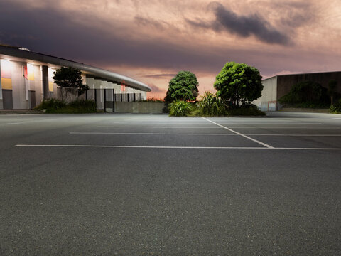 Car background, automotive backplate, empty car parking garage or parking area at dusk with artificial light