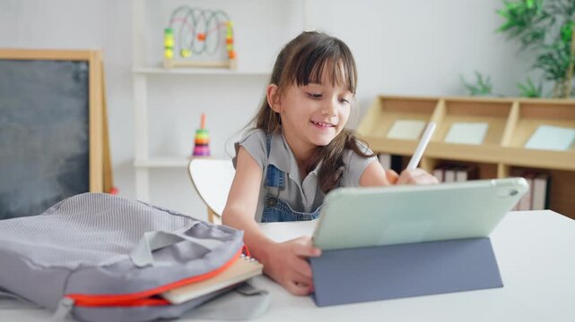 Caucasian young kid learning online class with teacher in cozy house. 