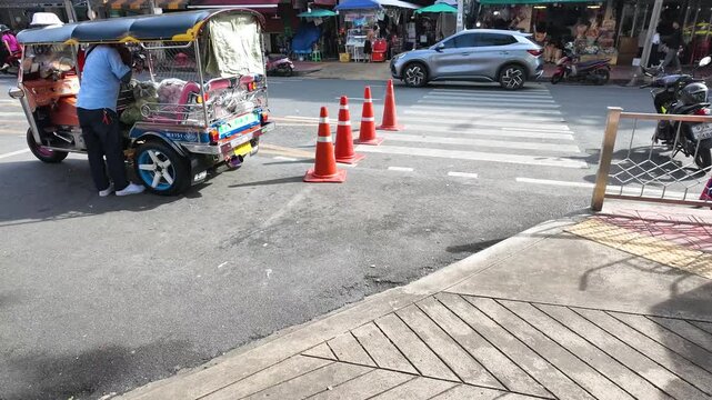 Blue Tuk Tuk Parked Near Crosswalk on Busy Bangkok Street