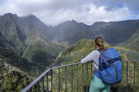 Rainbow, Young woman at the Miradouro dos Balc&otilde;es viewpoint, Ribeira da Metade mountain valley and the central mountains, Madeira, Portugal
