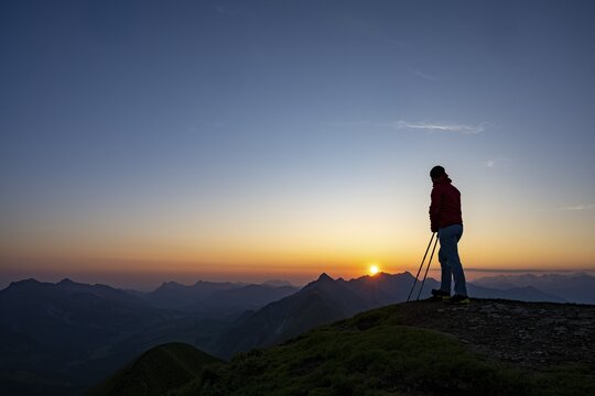 Mountaineer on mountain ridge with Rothorn peak in the background at sunrise, Interlaken, Bernese Oberland, Switzerland