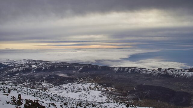 From Pico del Teide, Teide summit, panoramic views over snow-covered mountains and underlying clouds under a cloudy sky, Teide National Park, Teide National Park, volcano, volcanism, UNESCO World Heritage Site, Tenerife, Canary Islands, Spain