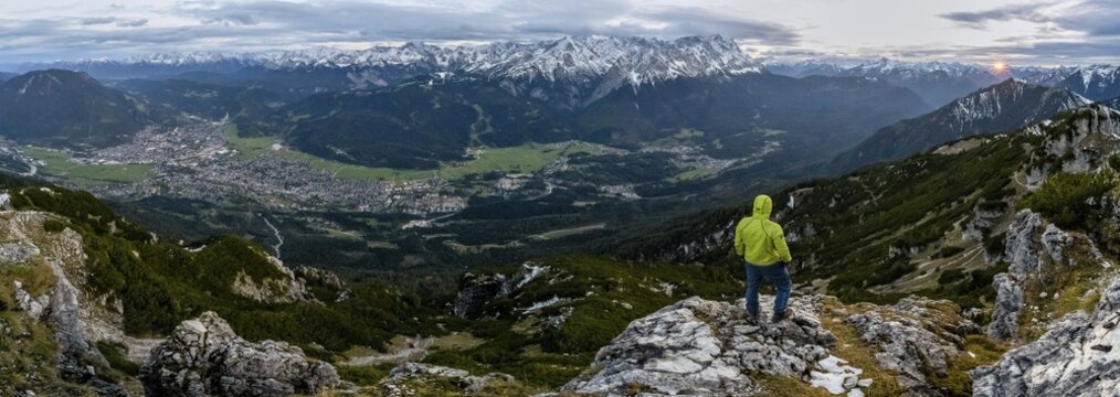 View Mountain panorama with Wetterstein mountains and Zugspitze, at sunset with sun star, mountaineer at the summit of the Kramerspitz, in autumn, Ammergau Alps, in autumn, Bavarian Prealps, Bavaria, Germany