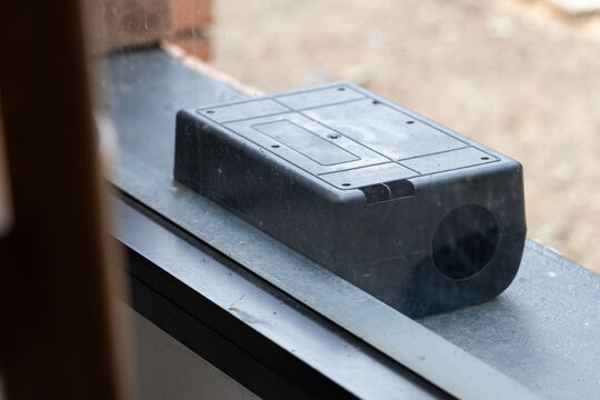 A black plastic rat trap on concrete floor. bait poison box for rat.