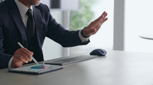 タブレットPCを使って作業する男性ビジネスパーソン。VR、バーチャル、画面、タッチ、操作、ビジネス