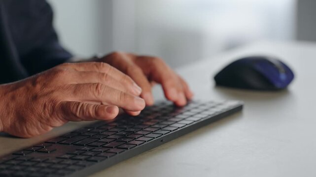 PCキーボードを操作する男性ビジネスパーソン。タイピング、入力、プログラミング、システム、エンジニア