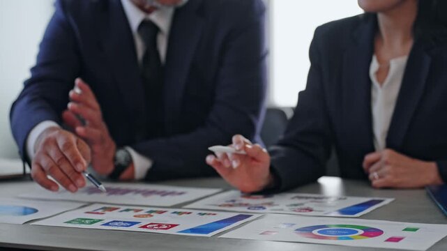 書類を見ながら会議する男女ビジネスパーソン。討論、議論、商談、会話、相談、営業、指導、研修、経営