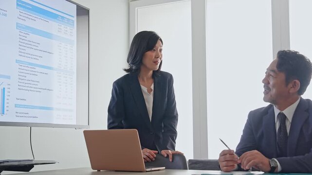 画面を見ながら会議するビジネスパーソンのグループ。経営、戦略、相談、会議、ミーティング、チームワーク