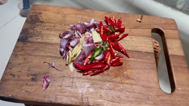 Chopped fresh red chili and shallots on wooden cutting board
