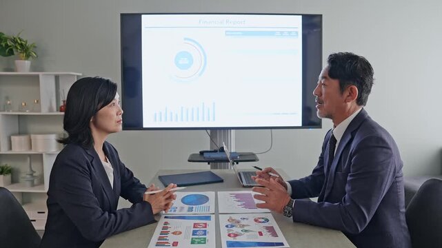 画面を見ながら会議する男女ビジネスパーソンのグループ。面談、面接、商談、提案、プレゼン、経営、企業