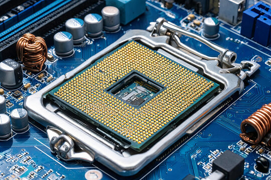 A close-up view of a computer motherboard's CPU socket, showing dense processor pins and surrounding electronic components.