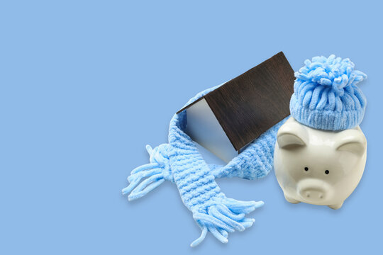 Cozy winter accessories placed beside a piggy bank for savings