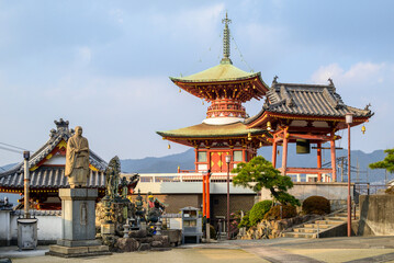 Obraz premium Traditional Japanese Buddhist temple complex with a pagoda and statues