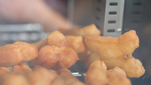 Golden Brown Fried Dough Sticks Displayed in a Glass Case