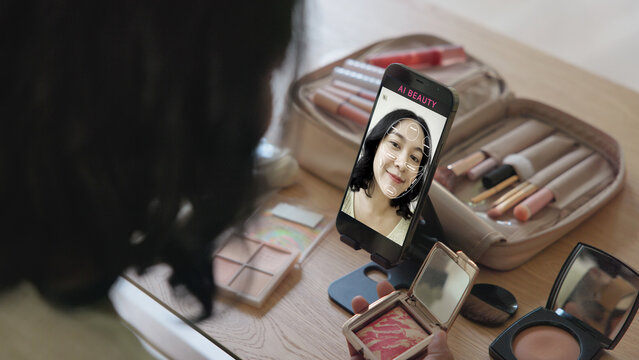 Asia people young gen z female happy smile enjoy phone apply selfie screen makeup blush virtual AI tech scan face app AR mixed augmented reality future beauty smart iot skin care help guide advice.