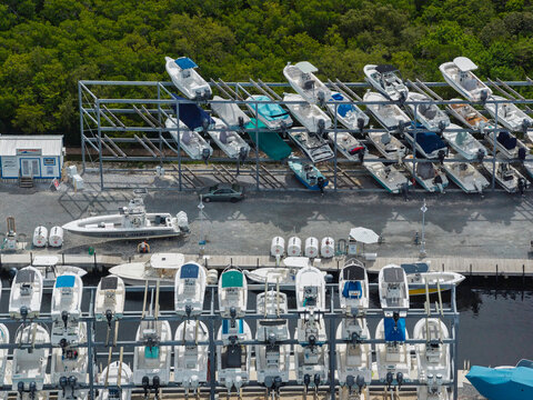 Aerial top down view of a marina in Islamorada with motorboats docked in the water and stored in a rack system