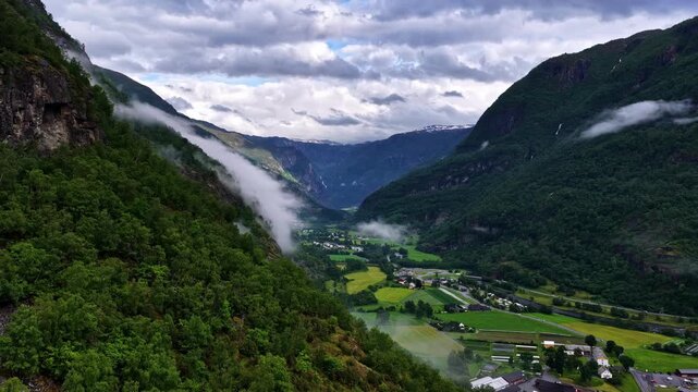 Time lapse of Norwegian fjord and township surrounded by mountains.