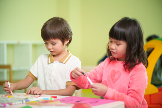 Preschool children enjoy drawing and creative art activities together in a colorful classroom, encouraging imagination, concentration, and early learning.