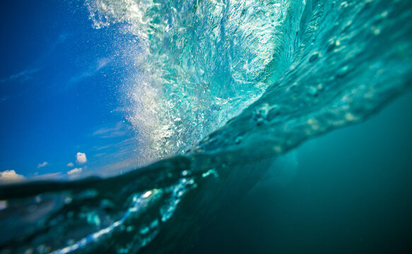Splashing Ocean Wave Closeup - Turquoise Water Surface and Blue Sky