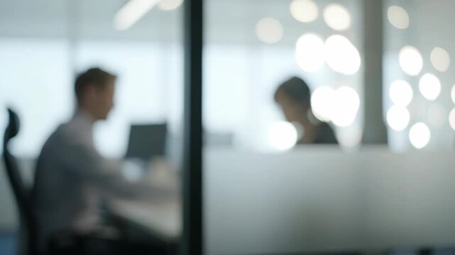 Two business people in a meeting in a modern office with blurred background