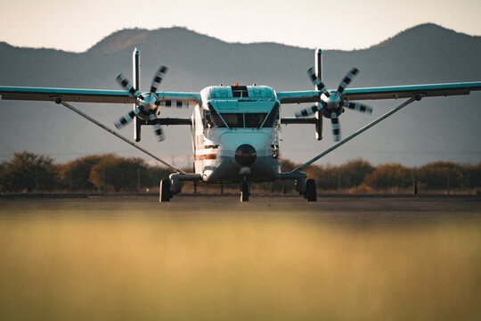 Twin-Engine Turboprop Aircraft Sky Van on Runway Front View With Spinning Propellers and Mountain Backdrop