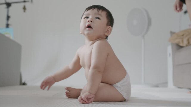 4K Cute Asian baby boy crawling on the floor and smiling happily.