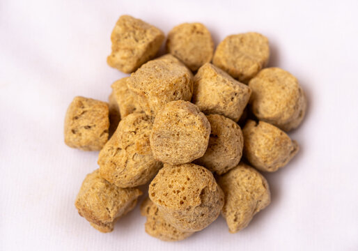 Raw soya chunks on white background. Healthy protein rich nutritious soybean meat, dry chunks isolated. Vegetarian food concept.