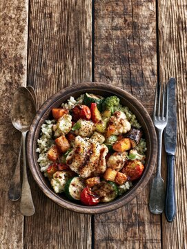Roasted vegetable bowl with rice on rustic table