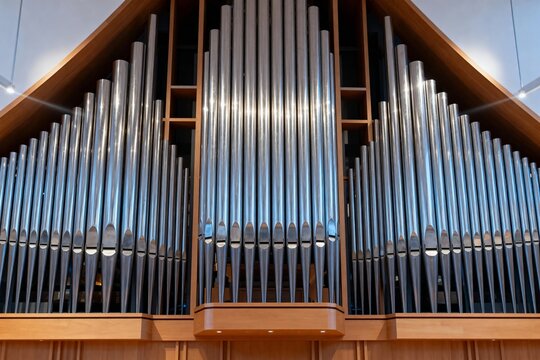 Close-up view of a large pipe organ with polished metal pipes arranged in symmetrical rows within a wooden frame