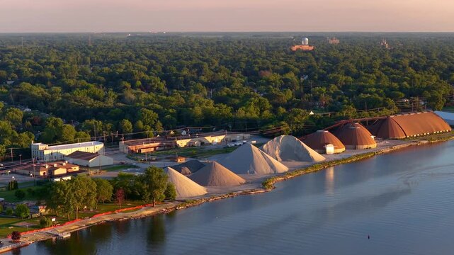 Aerial view of an industrial harbor with sand piles at sunrise
