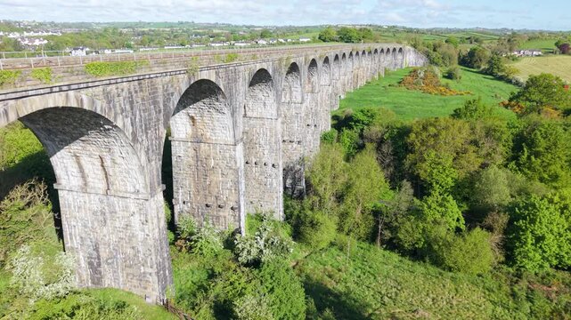 Historic stone railway viaduct spans lush green valley in rural Northern Ireland