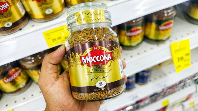 Malaysia Kuala Terengganu 17 July 2026: A hand holding a 100g jar of Moccona Espresso Style 10 bold and intense instant coffee in a supermarket aisle.