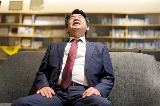 仕事に疲れてうなだれるビジネスマン