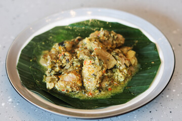 Fototapeta premium A plate of Babi Bulu or Babi Buluh, a traditional Manadonese dish featuring tender pork marinated in aromatic local spices and slow-cooked inside a bamboo stalk, served on a plate.